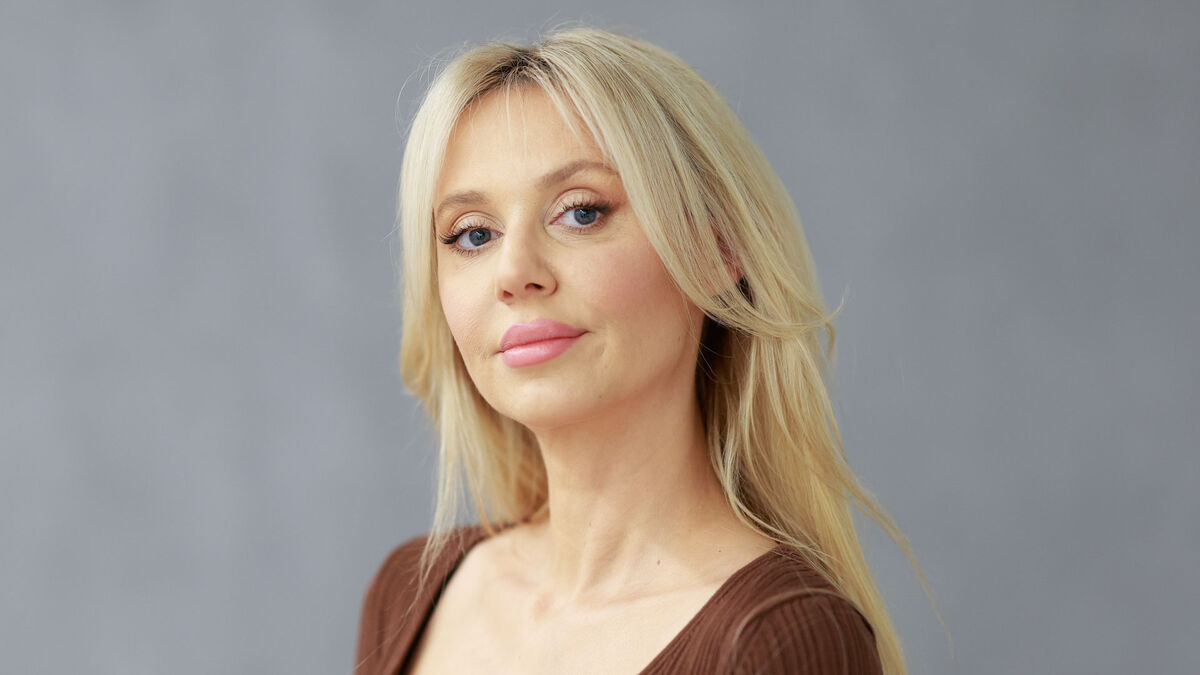 Kasia Moś i Karolina Lyndo: nowy projekt muzyczny z premierą w Pytaniu na śniadanie. Portret kobiety o jasnych włosach wykonany na jednolitym tle, ujęcie obejmuje twarz i ramiona. Osoba ma naturalny makijaż i ubrana jest w gładką bluzkę w stonowanym kolorze.